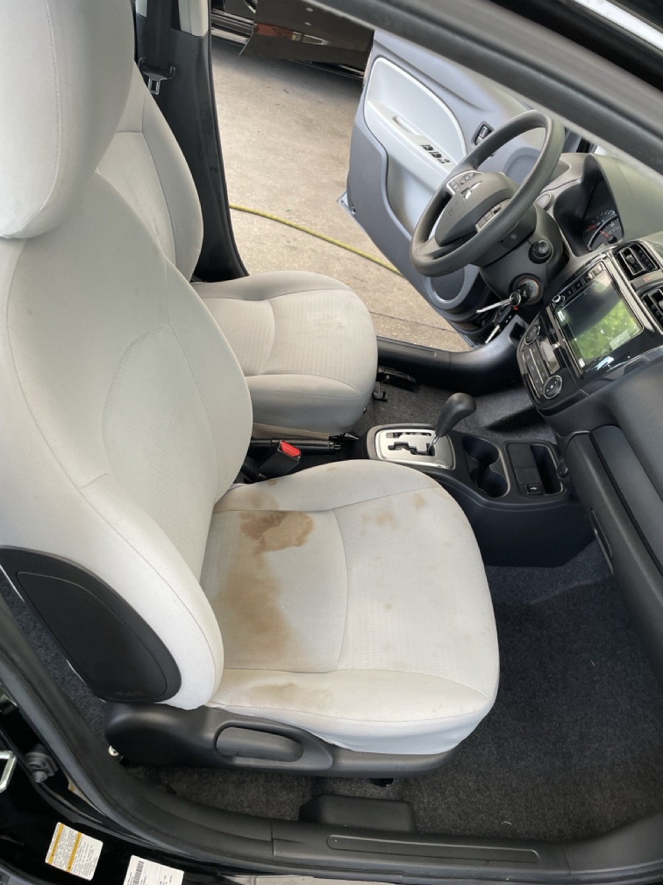 Cloth vehicle seat before cleaning with heavy staining